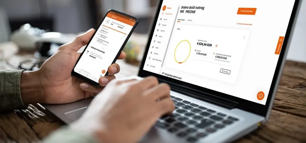 Osoba koja koristi PBZ mobilno bankarstvo na pametnom telefonu i prijenosnom računalu, pri čemu oba zaslona prikazuju nadzornu ploču za online bankarstvo s podacima o računu, što olakšava prelazak na novi mobitel kada je to potrebno.