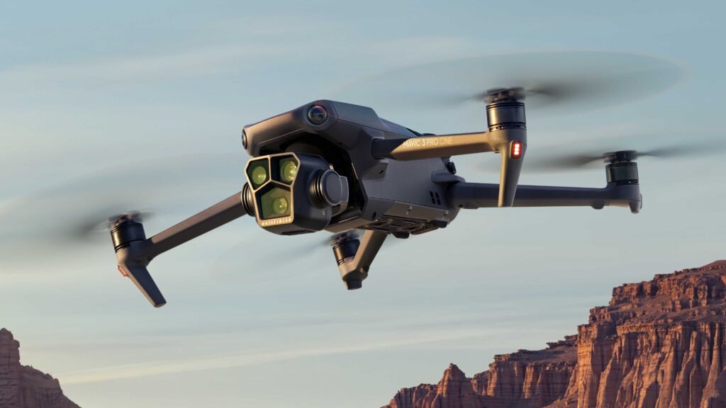 Crni kvadkopter dron s kamerom leti iznad stjenovitih pustinjskih litica pod vedrim nebom, savršen za one koji traže preporuke dronova za zapanjujuće zračne fotografije.