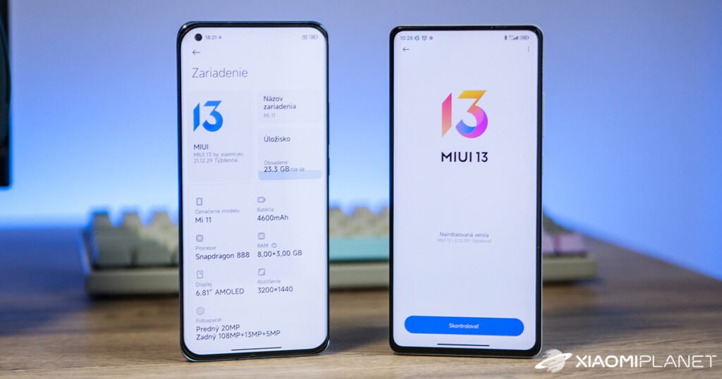 Dva pametna telefona prikazuju zaslone za postavljanje MIUI 13; lijevi prikazuje specifikacije uređaja na slovačkom, dok desni korisnicima predstavlja MIUI 13. U pozadini je tipkovnica - savršena scena za istraživanje najboljih aplikacija za prijenos podataka na novi mobitel.