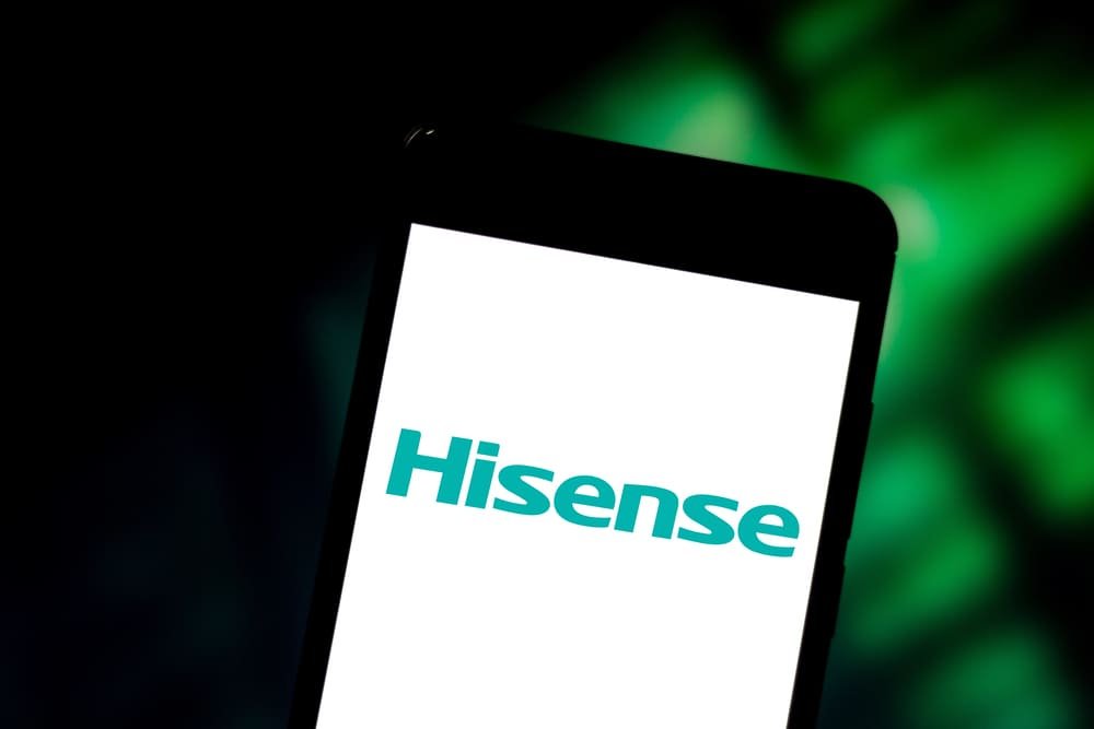 Zaslon pametnog telefona prikazuje Hisenseov logotip na bijeloj pozadini, s mutnom zelenom pozadinom iza telefona, ističući korisnička Hisense iskustva i pregled proizvoda.