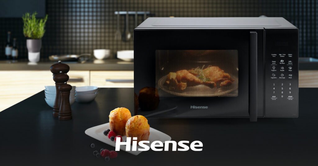 Hisense mikrovalna pećnica na kuhinjskom pultu s hranom unutra, u pratnji tanjura muffina i bobičastog voća u prvom planu - uvid u pozitivna Hisense iskustva u vašoj svakodnevnoj kuhinji.