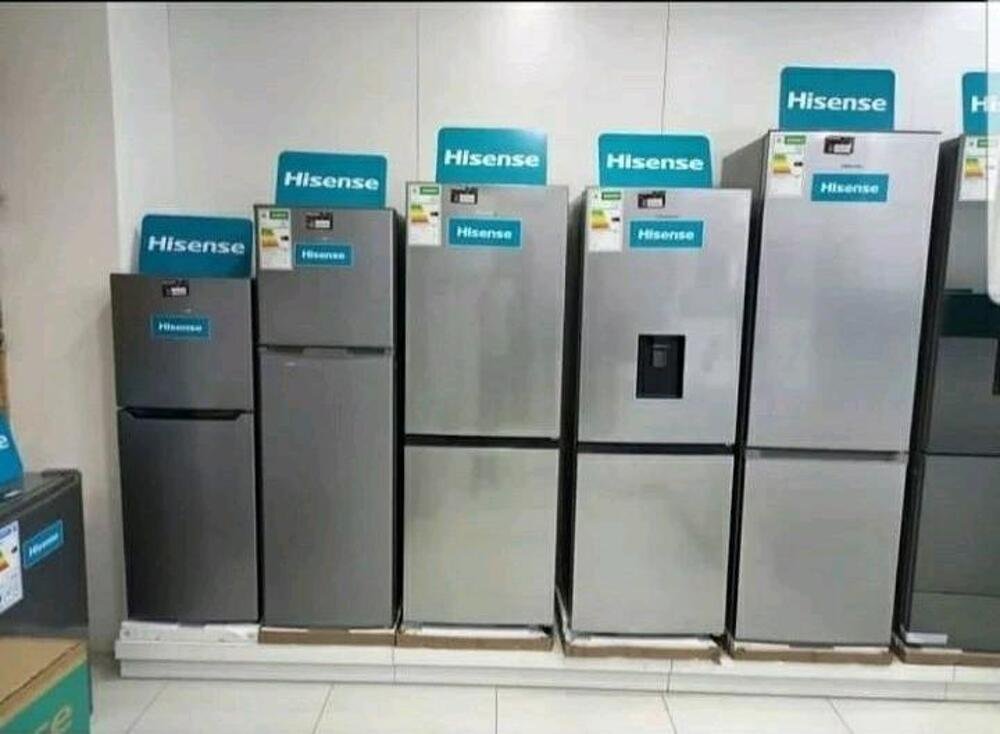 Pet Hisense Hladnjaka različitih veličina izloženo je u izložbenom salonu uz bijeli zid, svaki s logotipom brenda na vrhu, pozivajući kupce da istraže i podijele svoja iskustva ili ostave recenziju.