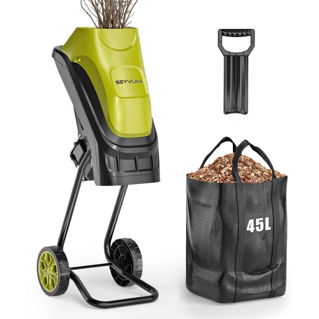 Zeleno-crna električna drobilica drva s ručkom koja usitnjava grane, pored crne vreće od 45 litara napunjene drvnom sječkom.